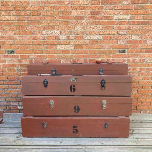 Cajas rojas de atrezo vintage usadas por equipos de iluminación de cine, colocadas en un backstage de rodaje