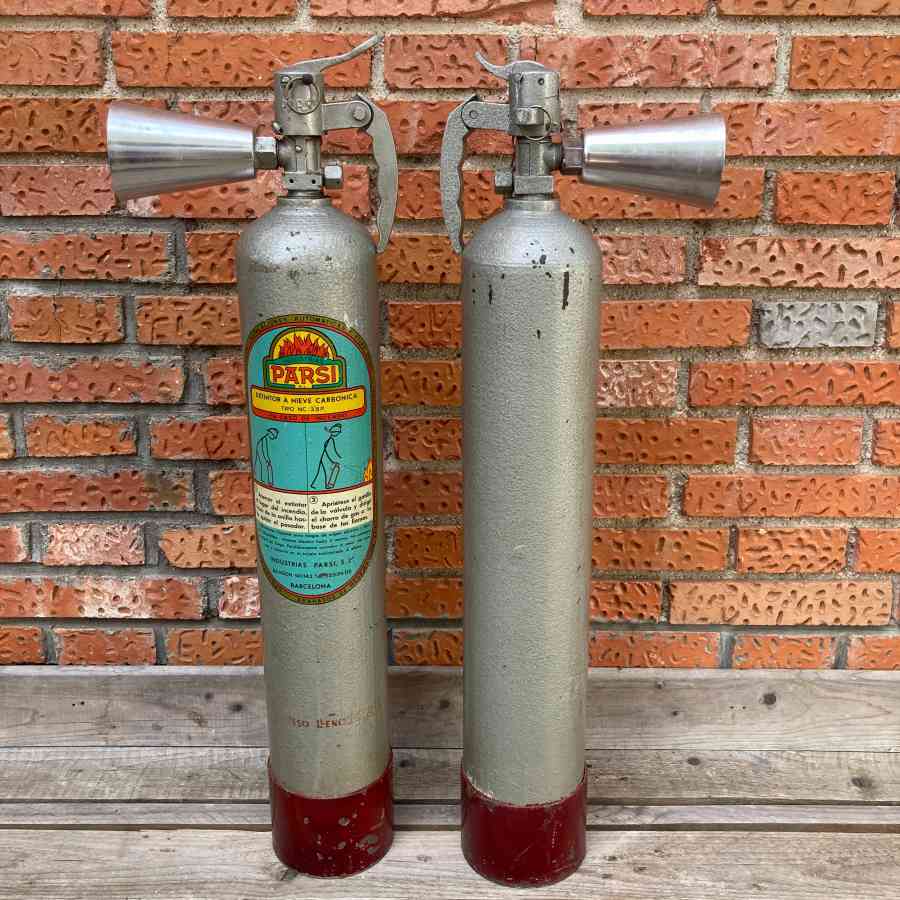 Extintor gris metálico vintage de época usado como atrezo en escenarios, pasillos o backstage.