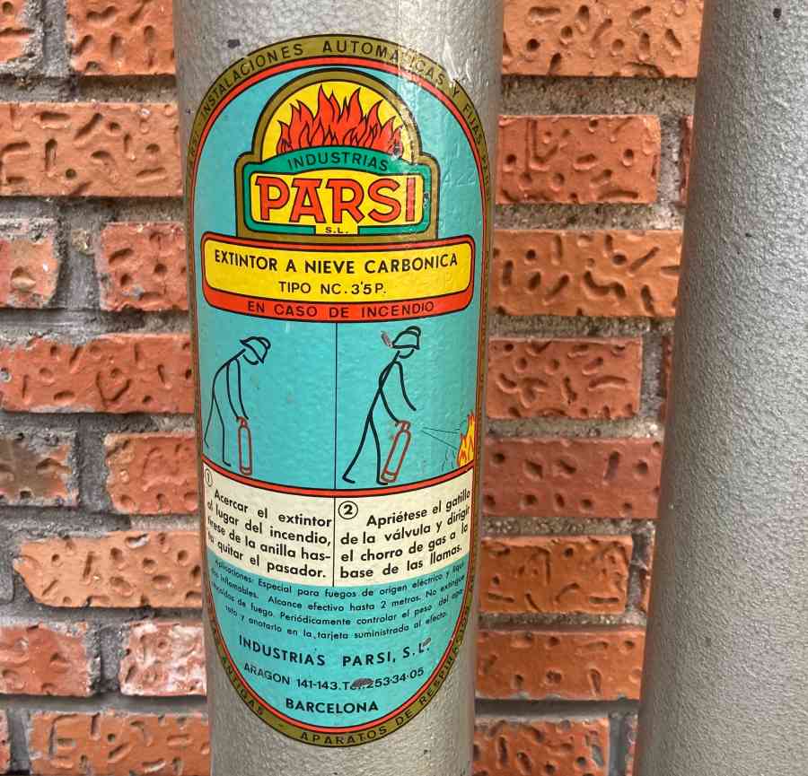 Extintor gris metálico vintage de época usado como atrezo en escenarios, pasillos o backstage.
